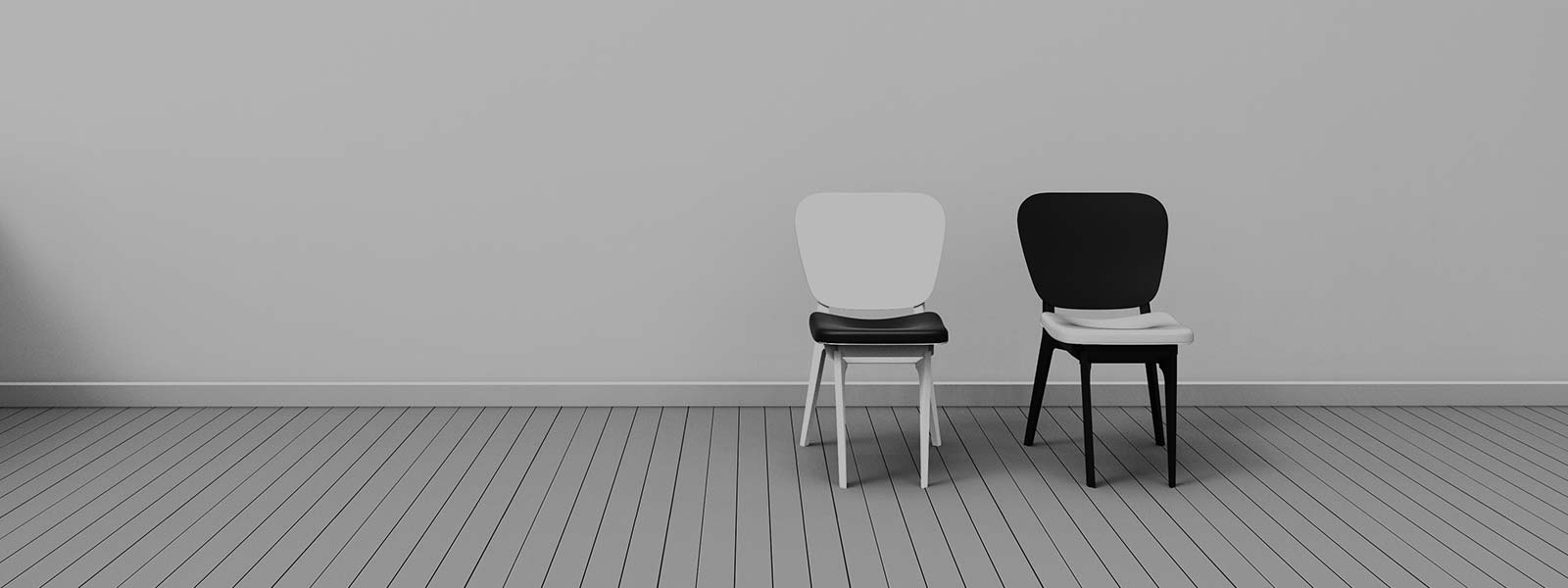 Two chairs next to one another in an otherwise empty room