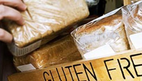 Hand picking up bread with a 'gluten free' sign