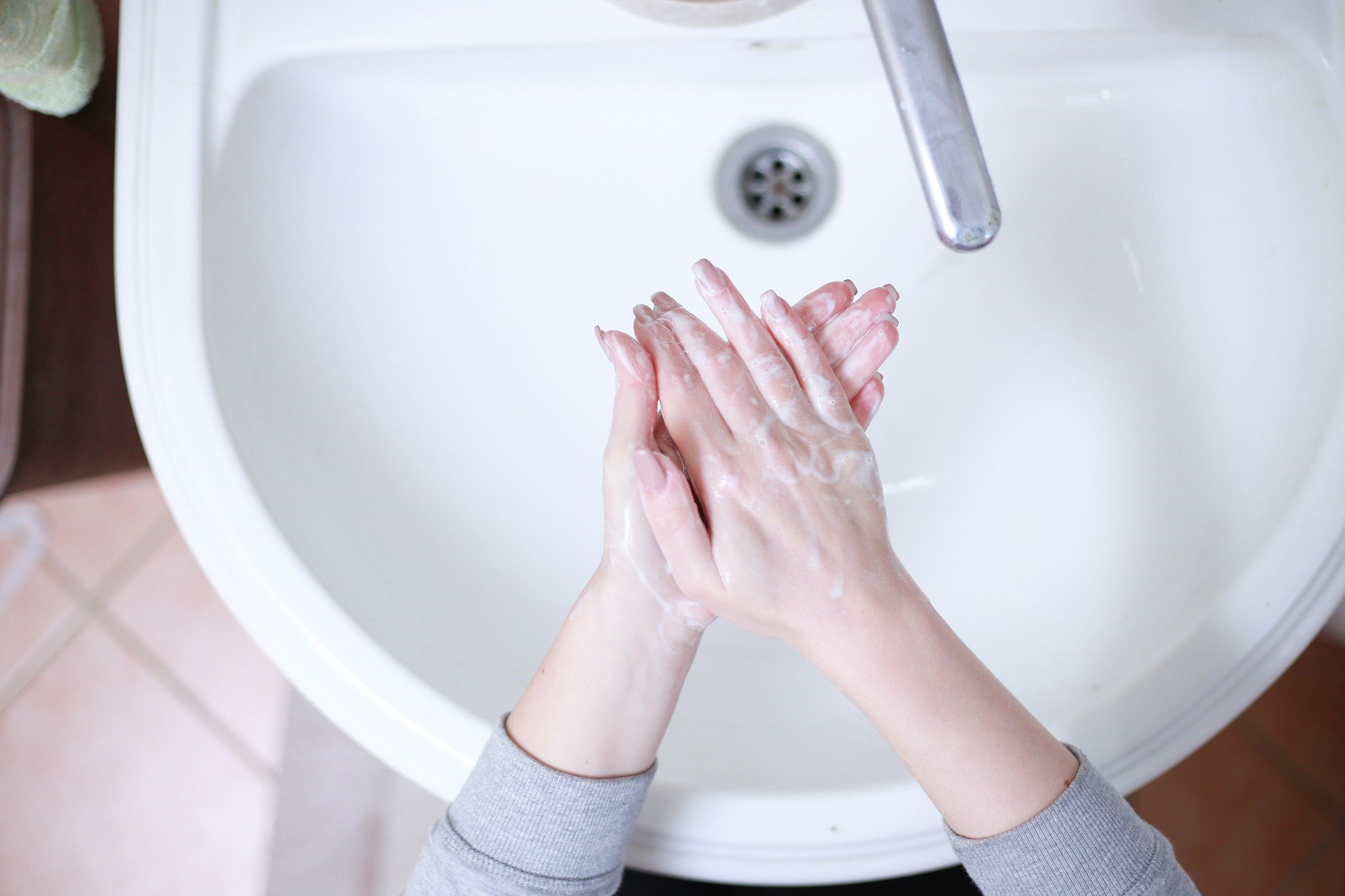 person washing hands in sink 