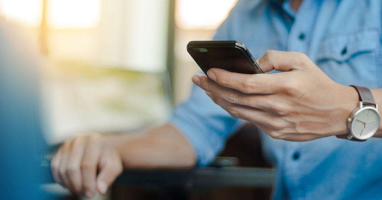 Close-up of man's hands holding a mobile phone.