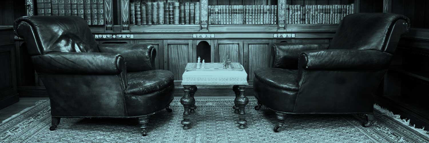 A reading room with two leather armchairs and a small coffee table