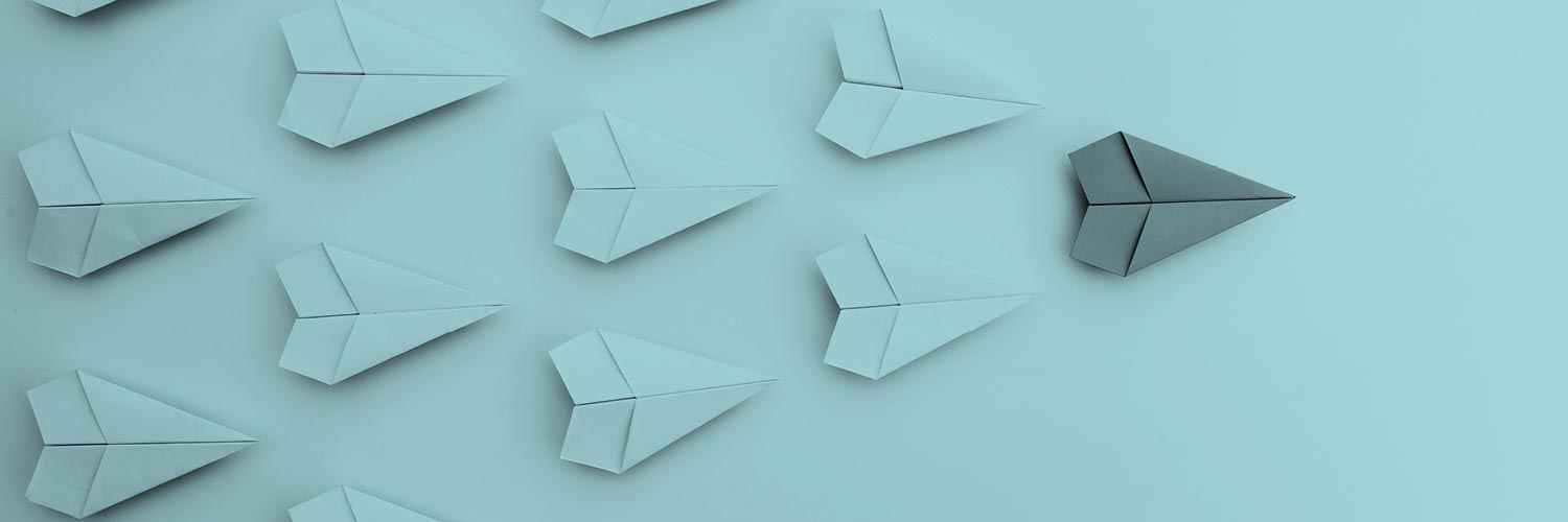 Paper aeroplanes set in a formation that points to the right