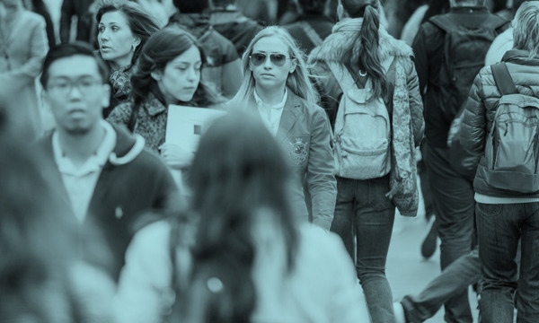 Lots of people walking on a crowded pavement 