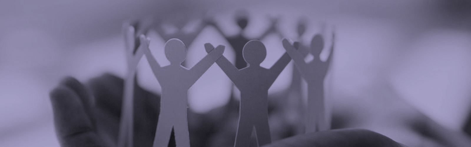 Hand holding cardboard cut-outs of people