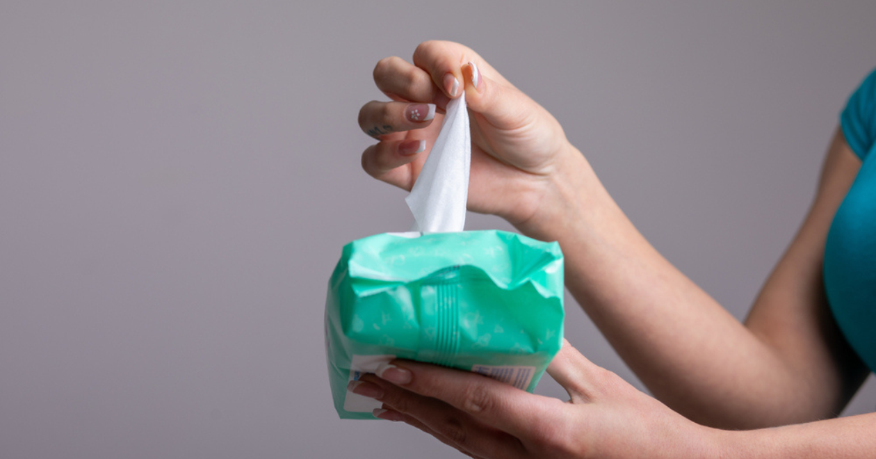 Person pulling baby wipe from packet