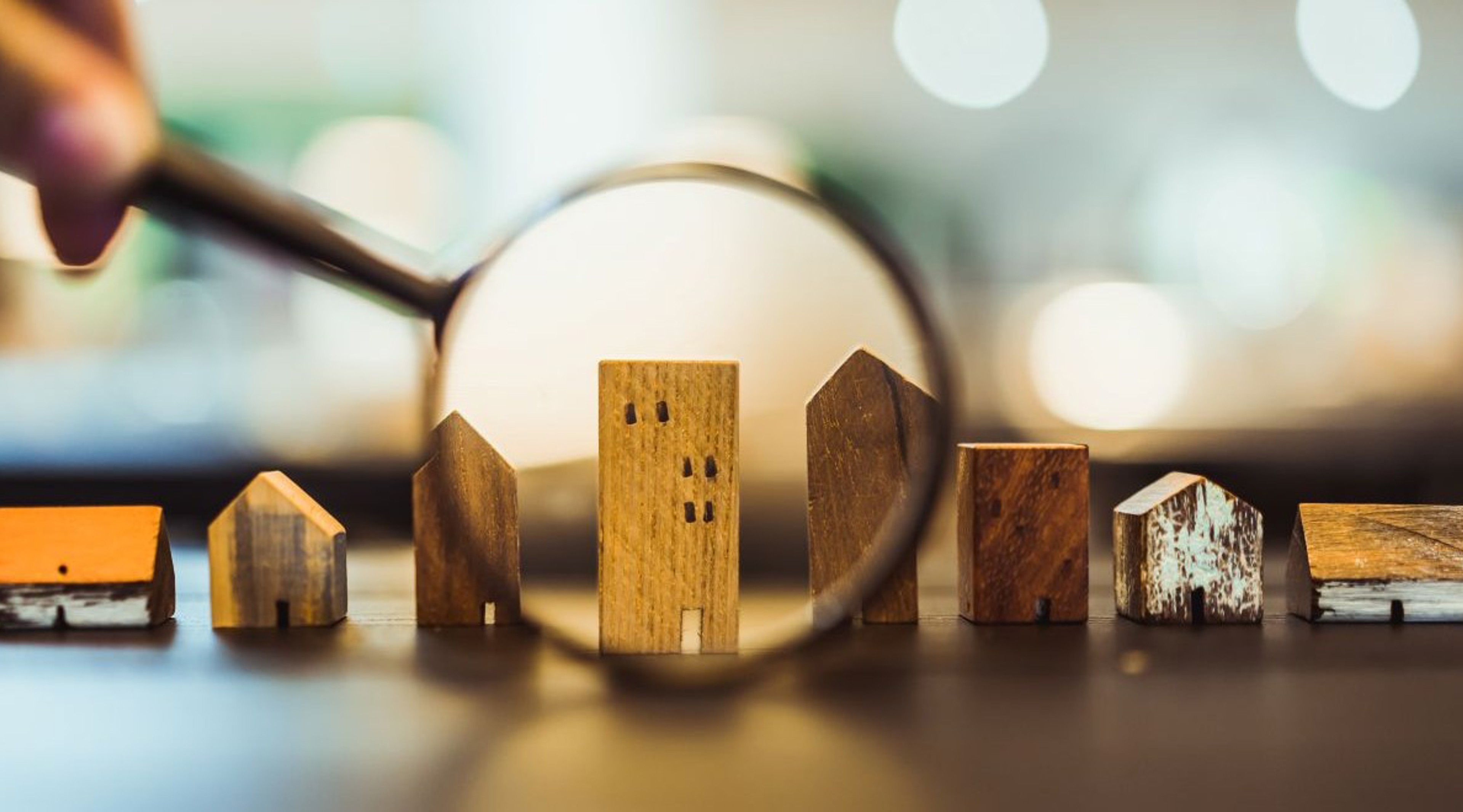 Row of wooden houses under a magnifying glass